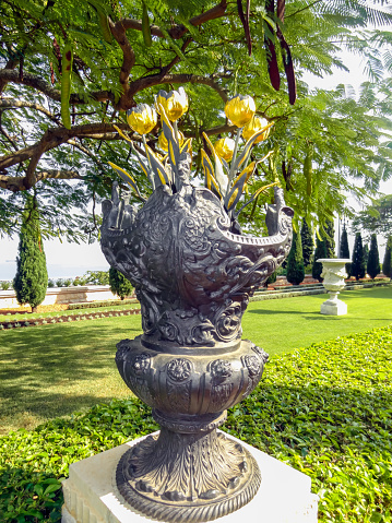 Garden decoration sculpture vase with golden flowers.