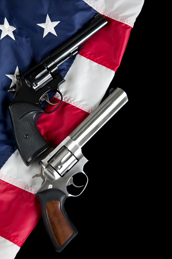 U.S. Second Amendment constitutional Right to Bear Arms. Revolver pistols resting on American Flag.