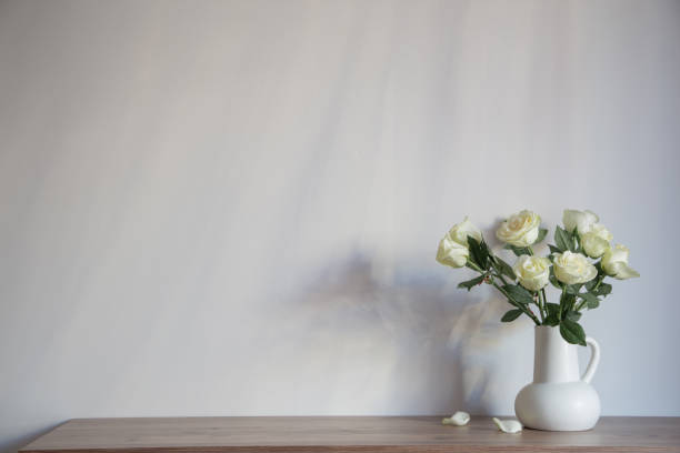 istock white roses in white jug on background gray wall 1817053889