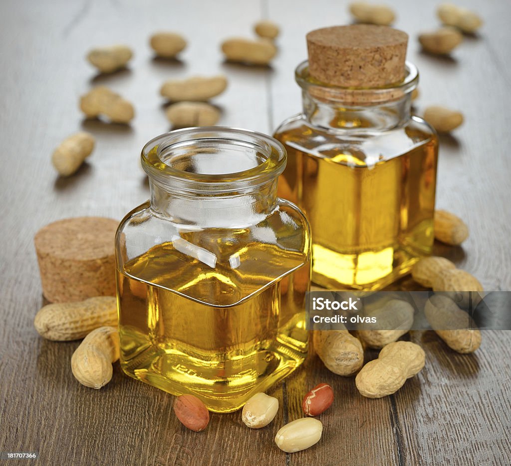 Peanut oil Peanut oil in a glass bottle on a brown background Cooking Oil Stock Photo