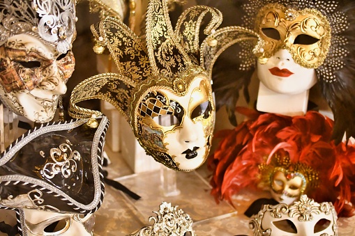 Golden venetian ball mask over dark background with copyspace. Masquerade party or holiday event celebration concept.