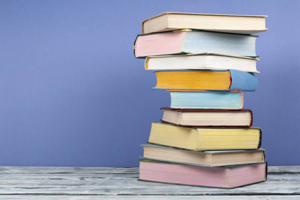 istock Open stacking book, hardback colorful books on wooden table and blue background. Back to school. Copy space for text. Education business concept. 1817075328