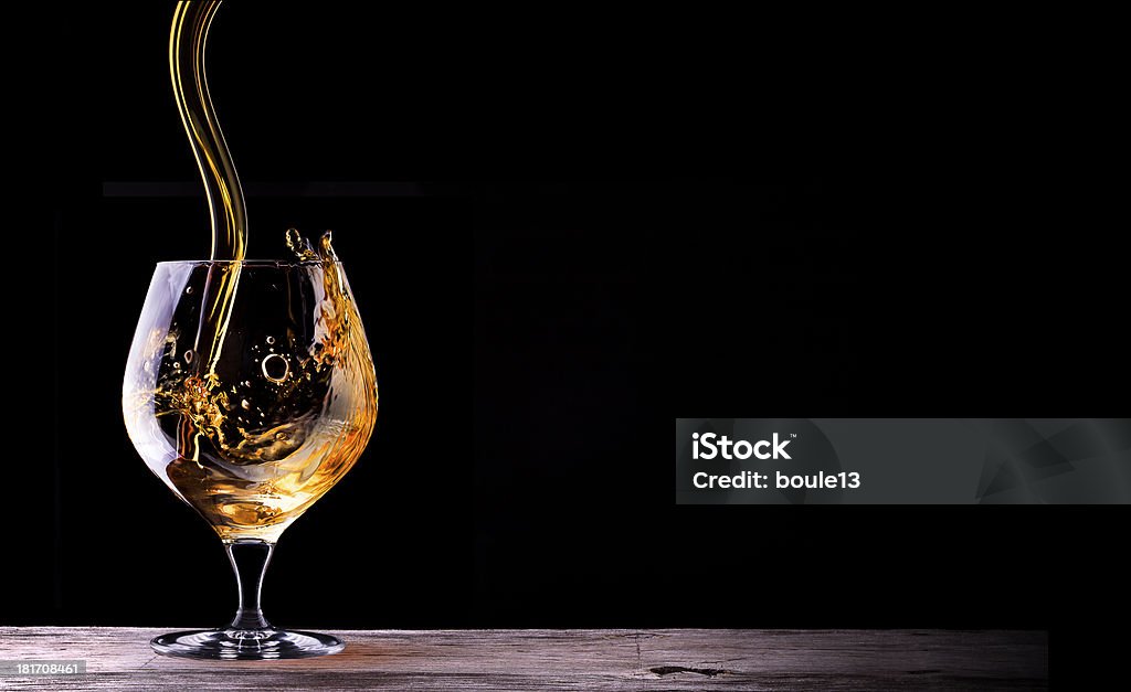 Cognac or brandy on a wooden table Cognac or brandy on a wooden vintage table with black background Cigar Stock Photo