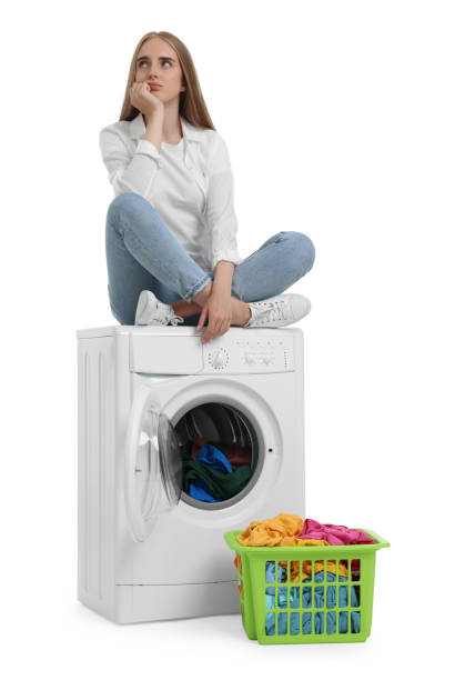 istock Upset woman on washing machine with laundry against white background 1817088080