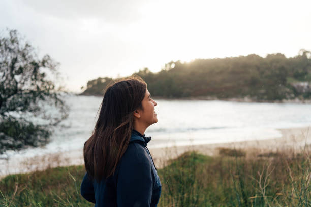 istock Young woman smiling in the beach at sunset 1817105343