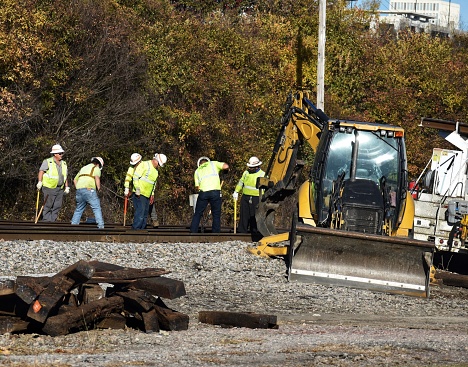 A work crew uses their hands and large machinery to perform regular railroad track maintenance on Norfolk Southern's R-Line in Columbia, SC.
