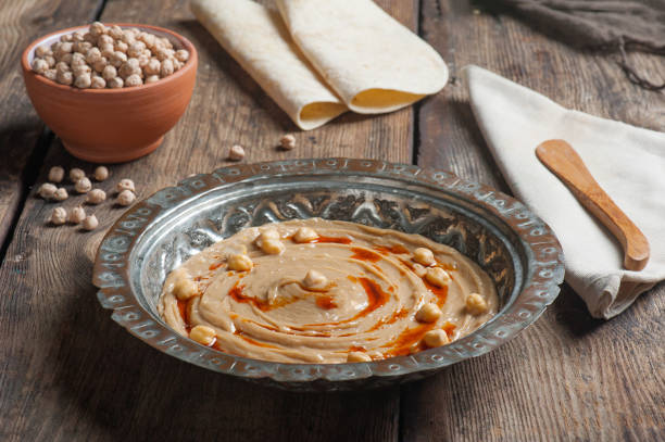 foto de �ángulo alto de humus en un plato de cobre tradicional con garbanzos crudos y panes planos en el fondo - lentil dinner holiday mediterranean cuisine fotografías e imágenes de stock