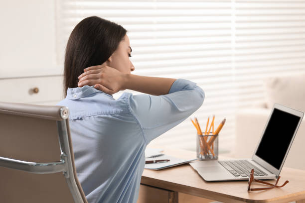 istock Woman suffering from neck pain at table in office 1817108371