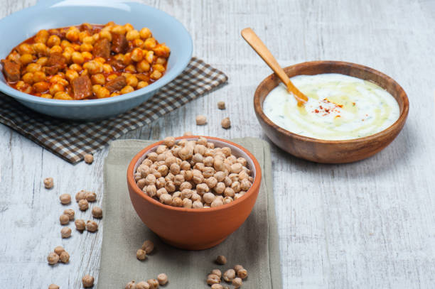 imagen de vista de ángulo alto de garbanzos crudos con plato tradicional turco de garbanzos y tzatiki en el fondo - lentil dinner holiday mediterranean cuisine fotografías e imágenes de stock