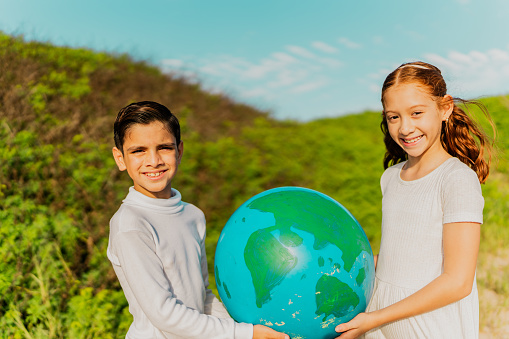 Portrait of a children holding a planet outdoors