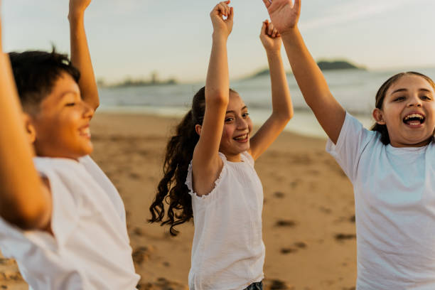 друзья-дети празднуют на пляже - community outreach child social worker waist up стоковые фото и изображения