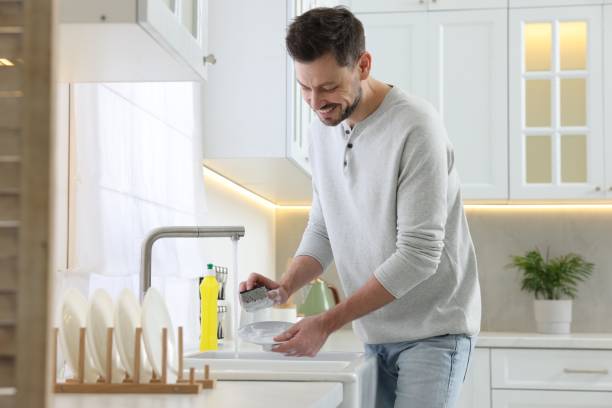 istock Man washing plate above sink in kitchen 1817137927
