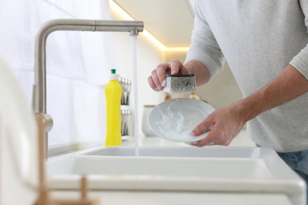 istock Man washing plate above sink in kitchen, closeup 1817137957