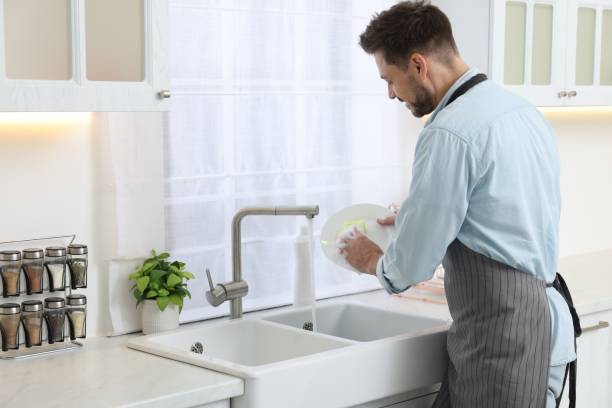 istock Man washing plate above sink in kitchen 1817137959