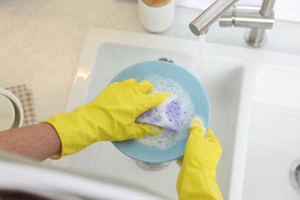 istock Man washing plate in kitchen sink, above view 1817139029
