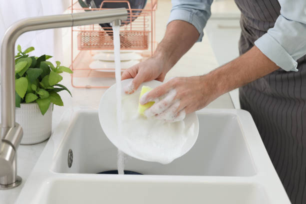 istock Man washing plate above sink in kitchen, closeup 1817139569
