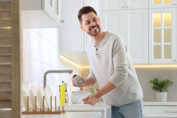 istock Man washing plate above sink in kitchen 1817139590