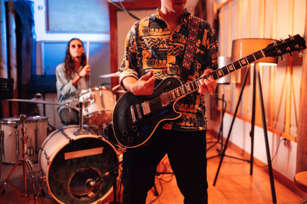 Group of middle aged men playing music together in a rehearsal studio