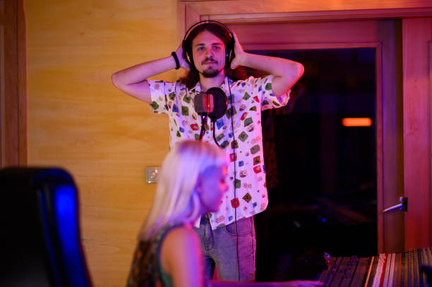 istock Portrait of vocal performer standing in recording studio, looking at camera. 1817142301