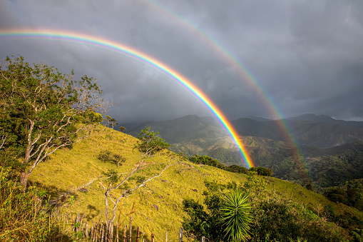 Beautiful double rainbow over lush green mountains.  Shot in Costa Rica.  Concepts could include travel, tourism, beauty in nature, adventure, others.