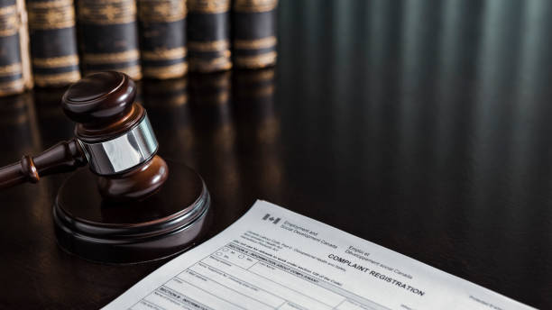 Canada Occupational Health and Safety Complaint Form with Gavel and Books Close up of a Canada Occupational Health and Safety Complaint form with a gavel and books. human rights act stock pictures, royalty-free photos & images