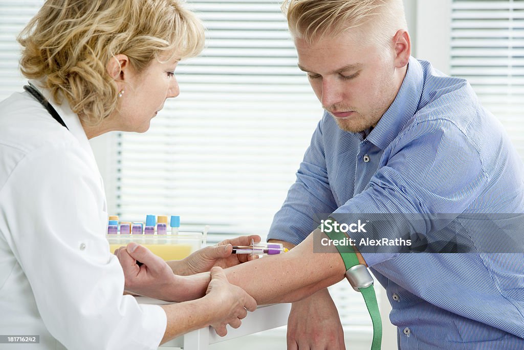 Nurse taking blood sample Nurse taking blood sample from patient at the doctors office. Blood Donation Stock Photo