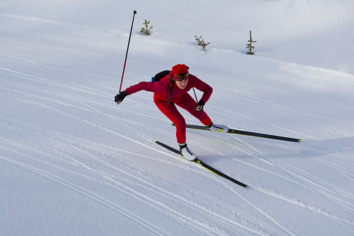 Side view of young male skier at straight downhill race, panning