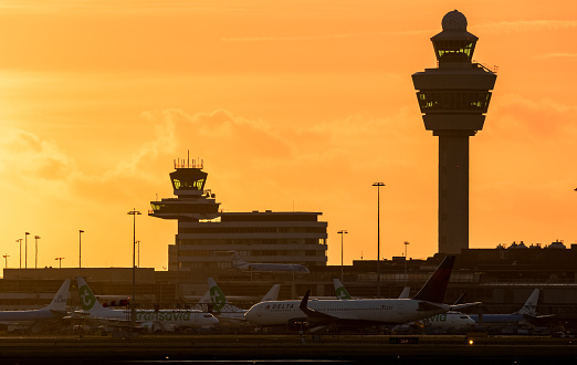 View on Amsterdam Schiphol International Airport with planes at the gates at sunset. Amsterdam, The Netherlands - January 9, 2019