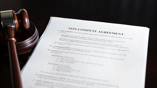 Close up of a non-compete clause agreement with a gavel.