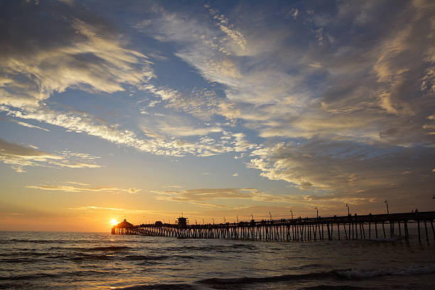 istock Sun setting over a pier stretching out over a body of water 181719303