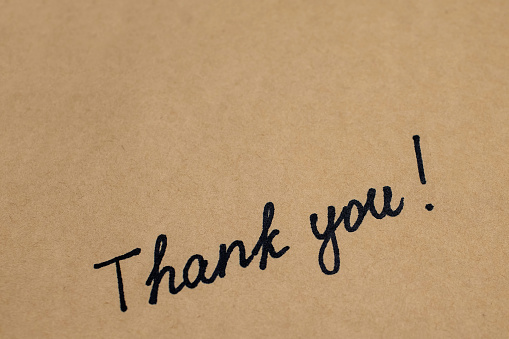 Thank you inscription by hand with a marker on brown paper in a notebook. Gratitude in the form of an inscription thank you with free space for text