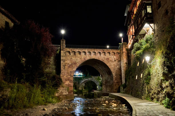 istock Potes mediaeval town at night with bridge and Deva river in its path. In the Liebana region, Cantabria, Spain. 1817195331