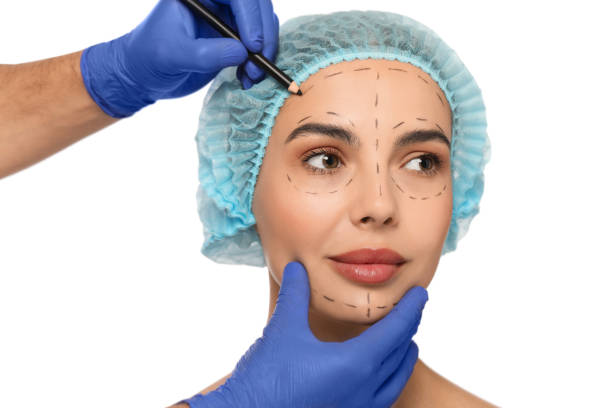 istock Doctor with pencil preparing patient for cosmetic surgery operation on white background, closeup 1817203975