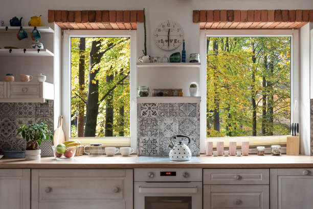Kitchen with view through window on forest and wooden countertop with oven. Home interior. Kitchen with view through window on forest and wooden countertop with oven. Home interior. Indoor architecture. modern cottage interior design stock pictures, royalty-free photos & images