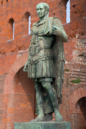 Turin, Italy - October 05. 2023: Bronze statue of Julius Caesar in front of the Porta Palatina in Turin in the Piemonte region of Italy. Roman history in northern Italy.