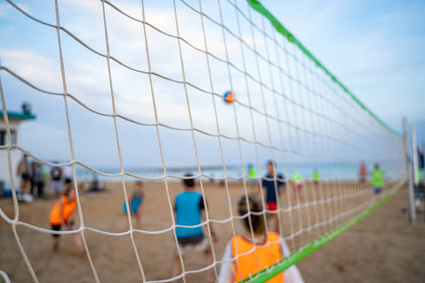 istock Group of young friends playing game volleyball on beach. Blurred background, selective focus. 1817253573