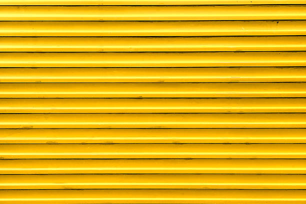 istock Yellow, steel, shiny rolling shutter door texture with horizontal lines 181726581