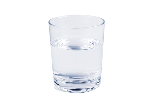 A young smiling woman drinks water at home