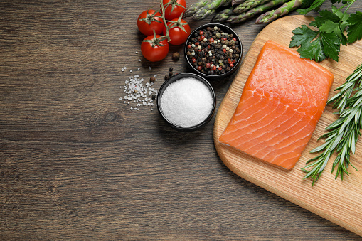 Fresh raw salmon and ingredients for marinade on wooden table, flat lay. Space for text