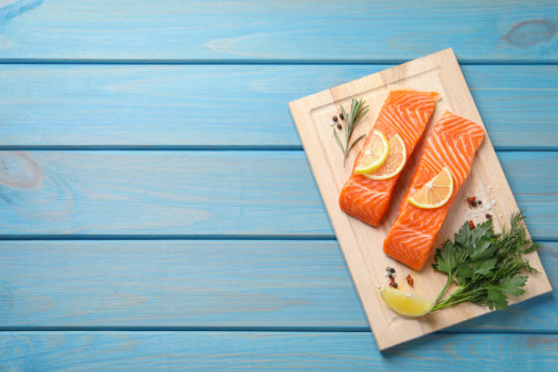 istock Fresh salmon and ingredients for marinade on light blue wooden table, top view. Space for text 1817311768