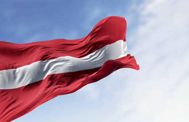 le drapeau national de la république de lettonie flotte au vent par temps clair - latvia flag photos et images de collection