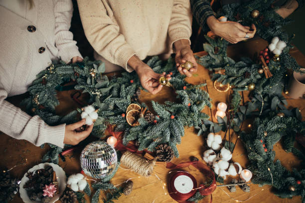istock Happy women making Christmas wreath using natural pine branches and festive decorations. 1817336598
