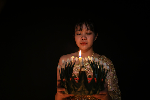 A lovely young  woman holding  Krathong  and praying for the God of Water in Thai tradition costume