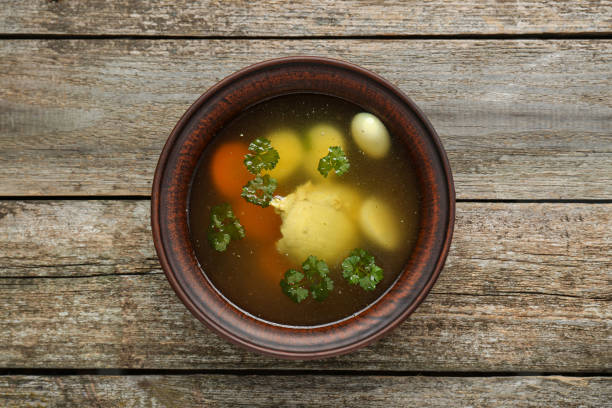 istock Delicious chicken bouillon with parsley, carrot and eggs on wooden table, top view 1817373842