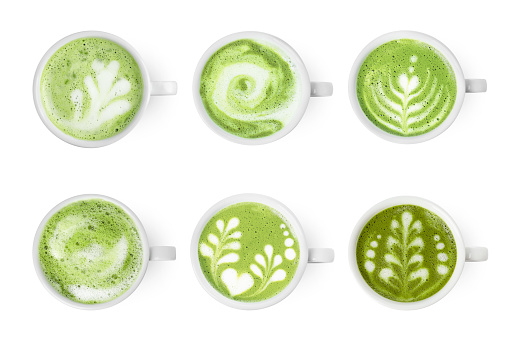 Set with cups of matcha latte isolated on white, top view