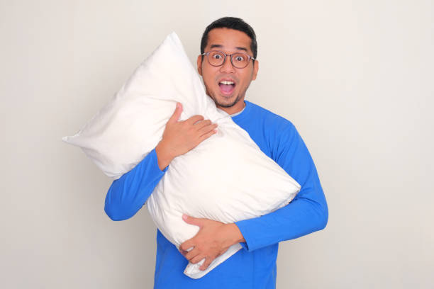 istock Adult Asian man showing funny shocked expression while hugging a sleeping pillow 1817401602
