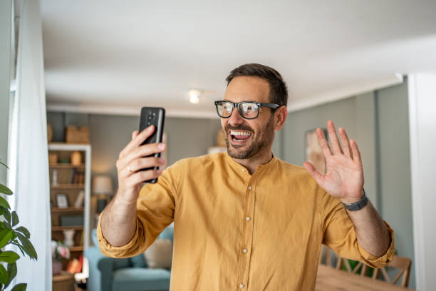 istock Handsome middle-aged Caucasian man taking a selfie or making a video call at home in his living room using a mobile phone 1817430885