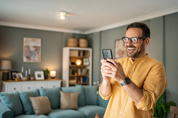 istock Handsome middle-aged Caucasian man taking a selfie or making a video call at home in his living room using a mobile phone 1817430903