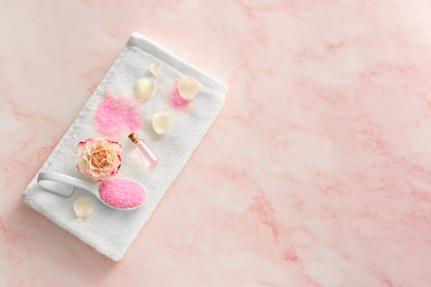 istock Aromatic sea salt, beautiful flower and petals on pink marble table, flat lay. Space for text 1817448217