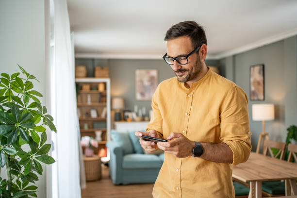 istock Portrait of cheerful man using smartphone at home 1817449681